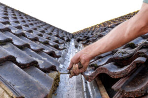 Uckfield, East Sussex. UK- November 17, 2023: The roofer lays a cement bed to fit edge tile on the roof.