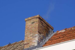 Smoking Restored brick chimney on the rooftop.