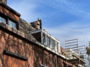 Brunssum  the Netherlands, - October 01, 2021.  Roofers on top  making a new masonry chimney for a wood stove.
